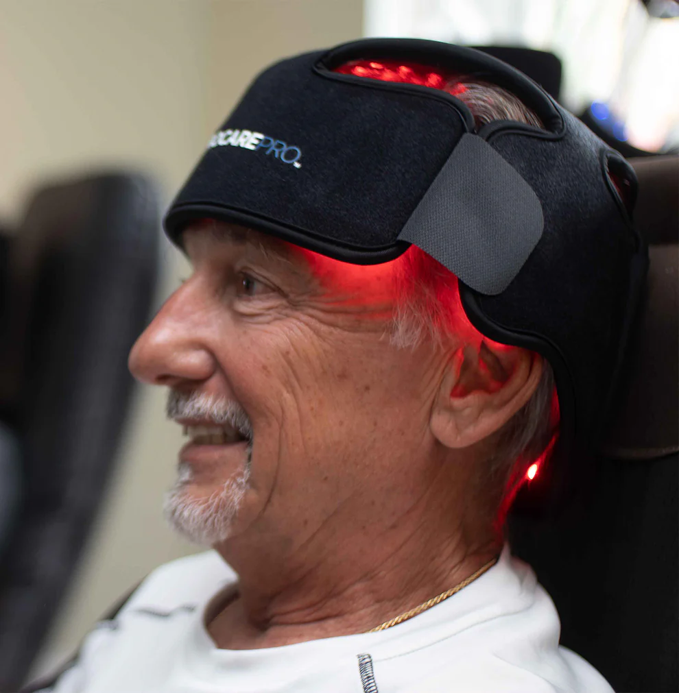 Man wearing a black headband with red lights, possibly for therapy or stimulation.